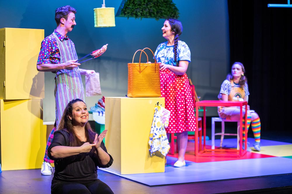 Kelly Hodgins signing on stage during a NZSL interpreted performance